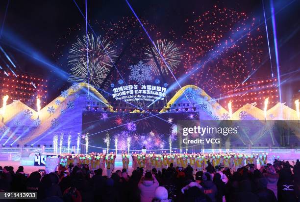 Tourists watch fireworks during the opening ceremony of the 40th Harbin International Ice and Snow Festival at the Harbin Ice and Snow World on...
