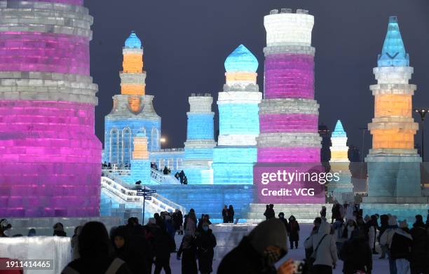 Tourists view ice sculptures illuminated by colored lights at the Harbin Ice and Snow World during the 40th Harbin International Ice and Snow...