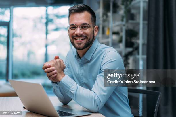 successful businessman in modern office working on laptop. - ejecutivo fotografías e imágenes de stock