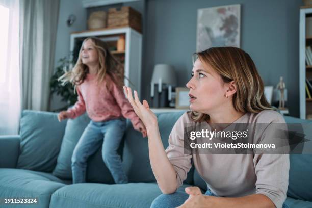 stressed mother having problem with noisy naughty daughter. - ongeduldig stockfoto's en -beelden