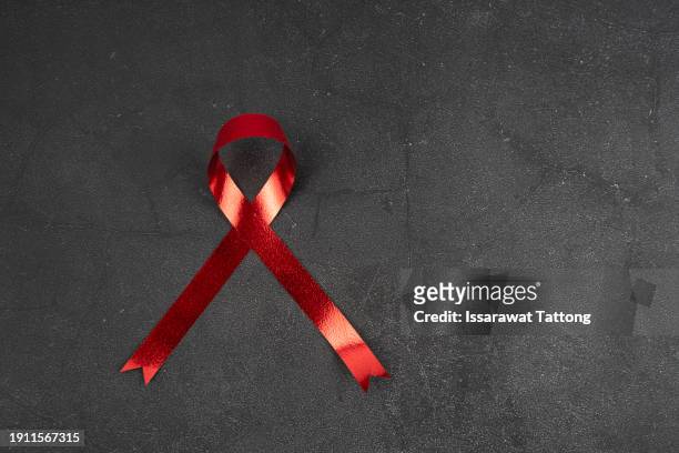 closeup red ribbon hiv, world aids day awareness ribbon on white background. healthcare and medicine concept. - world aids day stock pictures, royalty-free photos & images