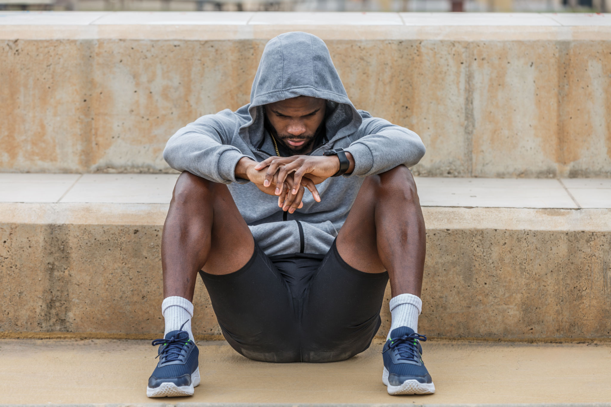 Depressed black sportsman sitting on ground Depressed black sportsman sitting on ground