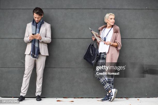 man and woman on a bus station - bushalte stockfoto's en -beelden
