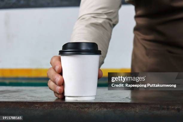 waiter holding and serving a paper cup of hot coffee - espresso drink stock pictures, royalty-free photos & images