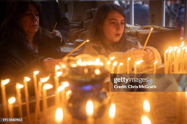 Girl lights a candle during the Epiphany mass as part of Epiphany day celebrations at the Church of Fener Orthodox Patriarchate on January 06, 2024...