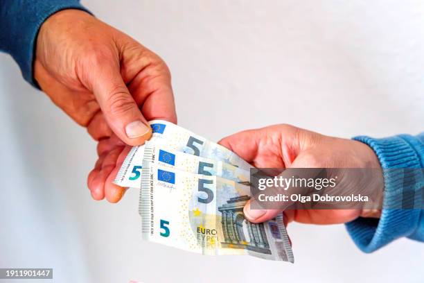 a woman giving 5 euro banknotes to a man - vijf euro stockfoto's en -beelden