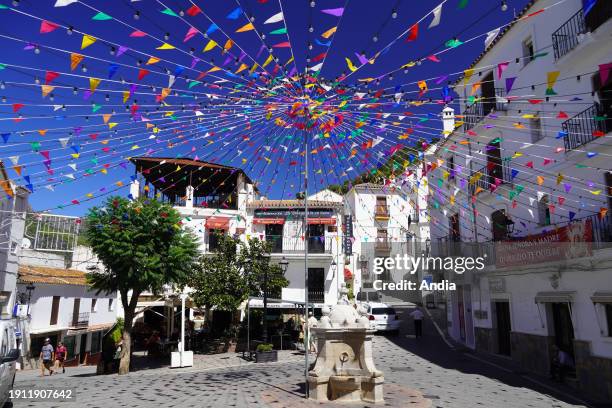 Spain, Andalusia, Province of Malaga, Casares: the central square with multicolored flags for the celebration of the “Virgen del Rosario, del Campo ,...