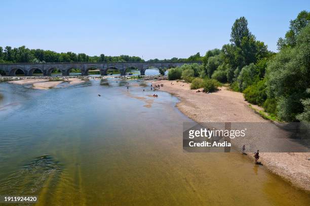 Beach on the banks of the Allier River at the bottom of the Guétin navigable aqueduct in Cuffy . Tourists enjoying the coolness of the Allier...