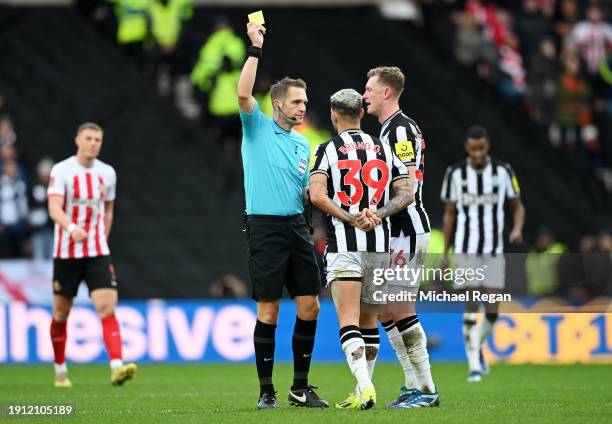 Referee Craig Pawson shows a yellow card to Bruno Guimaraes of Newcastle United during the Emirates FA Cup Third Round match between Sunderland and...