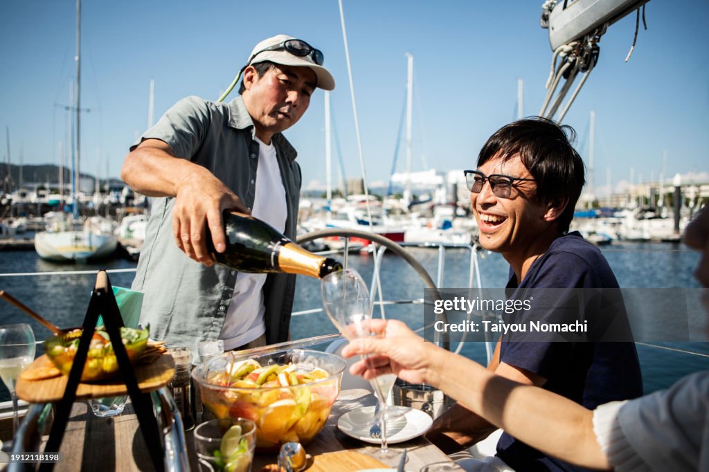 People enjoying a meal on a private yacht with friends