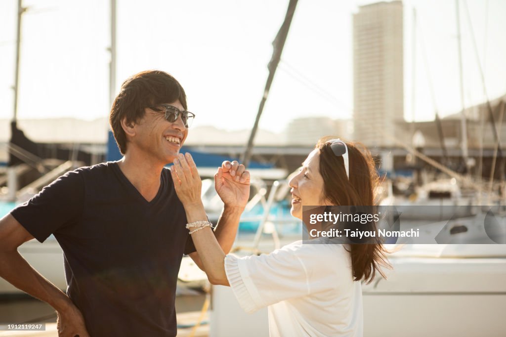 A portrait of a friendly Japanese couple who came to the yacht harbor for the weekend.