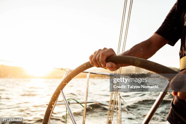 hands of a man operating a private yacht. - velero fotografías e imágenes de stock