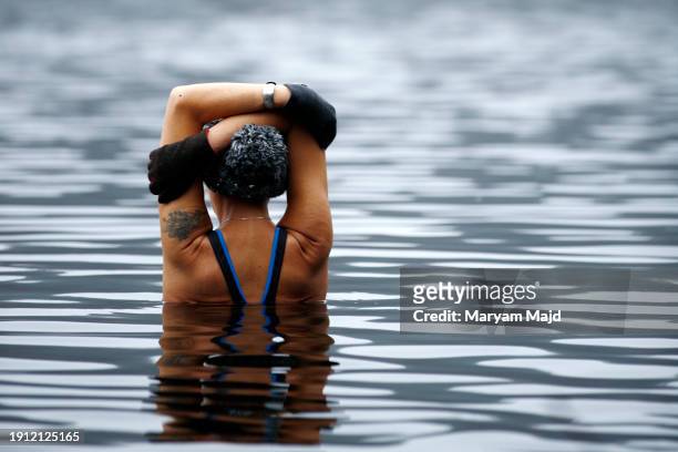 Woman meditates in Schlachtensee Lake during the Ice Dipping Movement challenge on January 06, 2024 in Berlin, Germany.