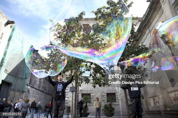 Men With Large Bubbles Made With Wands In The Town Square. Barcelona, Catalonia, Spain.