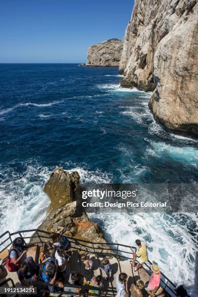 Tourists Descending To Neptune's Grotto In Capo Caccia. Alghero, Sardinia, Italy.