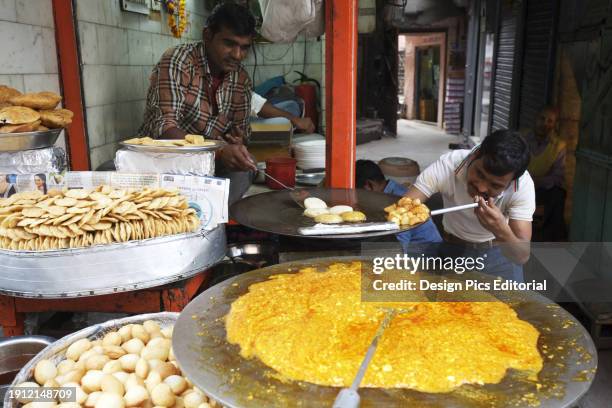 Man Cooking On A Tawa At Street Food Stall In Old Delhi.