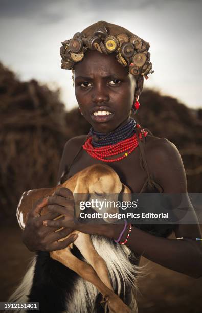 Young Tribal Woman Holding A Baby Goat, Omo Valley. Ethiopia.