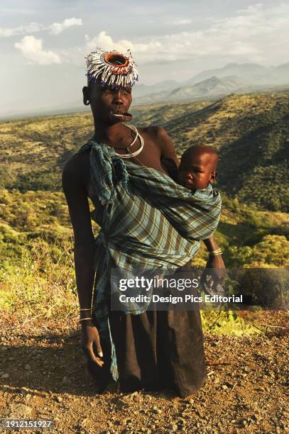 Tribesman With Baby And Plated Lip, Omo Valley. Ethiopia.