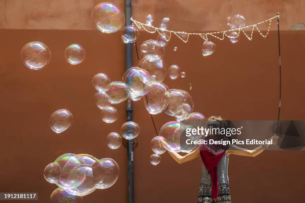 Young woman creating a performance with large bubbles. Spain.