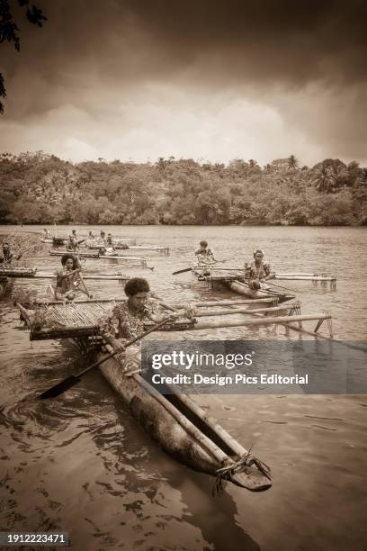 Melanesian woman in traditional dress with tapa bark cloth dress of Natade Village in outrigger canoes at the entrance to the Tufi Fjords of Cape...