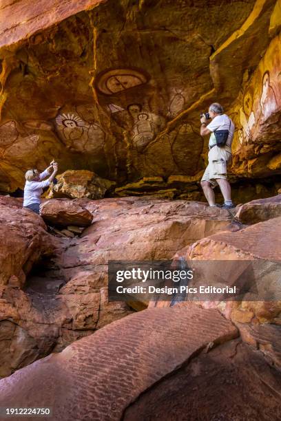 Tourists photograph Aboriginal Rock Art near Raft Point in the Kimberley Region.