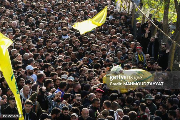 Hezbollah fighters and supporters attend the funeral of slain Hezbollah military commander Wissam Tawil, also know as Jawad, in his hometown of...