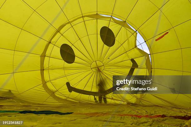 People inflating hot air balloons before flying during the 34th International Balloon Rally Of The Epiphany on January 6, 2024 in Mondovi, Italy. The...