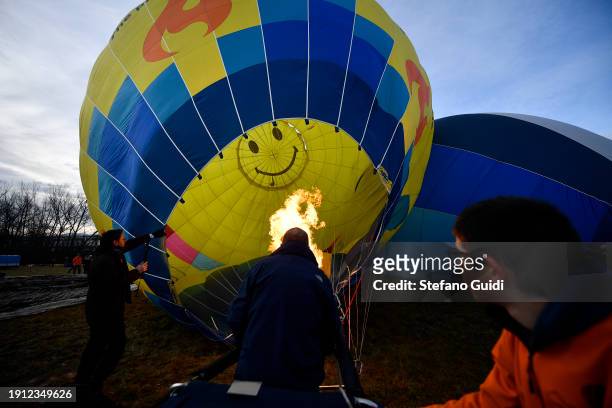 People inflating hot air balloons before flying during the 34th International Balloon Rally Of The Epiphany on January 6, 2024 in Mondovi, Italy. The...