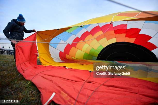 People inflating hot air balloons before flying during the 34th International Balloon Rally Of The Epiphany on January 6, 2024 in Mondovi, Italy. The...