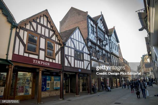 Pedestrians Walk Down A Street By Shops. Winchester, Hampshire, England.