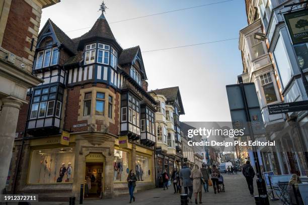 Pedestrians Walk Down A Street By Shops. Winchester, Hampshire, England.