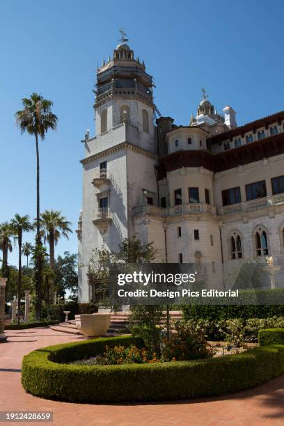 An exterior view of Hearst Castle and Casa Grande near palm trees. Hearst Castle, San Simeon, California.