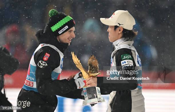 Ryoyu Kobayashi of Japan is presented with the Four Hills Tournament trophy by Halvor Egner Granerud of Norway after winning the FIS World Cup Ski...
