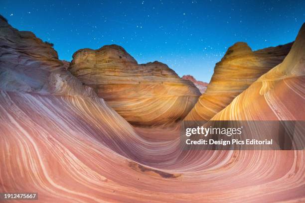 Shooting star passes over the Wave sandstone rock formation, located in Coyote Buttes North, Paria Canyon, Vermillion Cliffs Wilderness.
