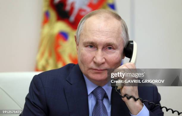 In this pool photograph distributed by Russian state agency Sputnik, Russia's President Vladimir Putin speaks on the phone with Kristina Sin, an...