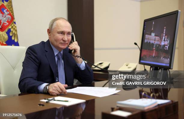 In this pool photograph distributed by Russian state agency Sputnik, Russia's President Vladimir Putin speaks on the phone with Kristina Sin, an...