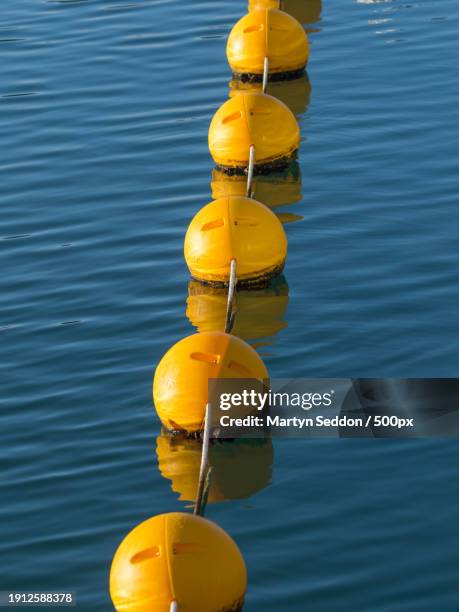 high angle view of yellow buoy floating on lake - buoy stock pictures, royalty-free photos & images