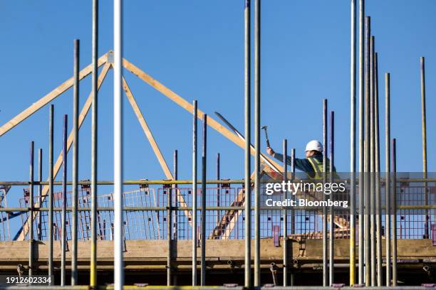 An employee hammers in a nail to a roofing joist at a Persimmon Plc residential property construction site in Braintree, UK, on Tuesday, Jan. 9,...