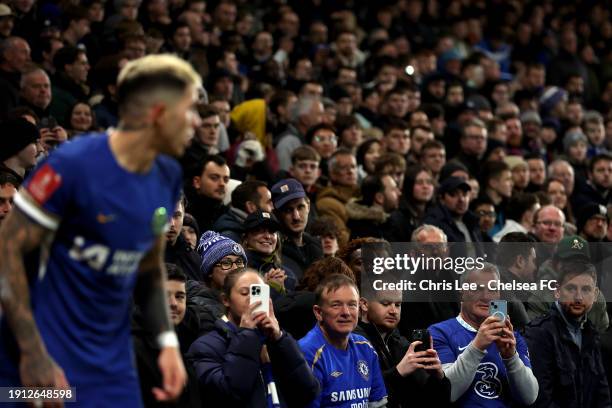 Chelsea fans can be seen pointing mobile phones toward Enzo Fernandez of Chelsea during the Emirates FA Cup Third Round match between Chelsea and...