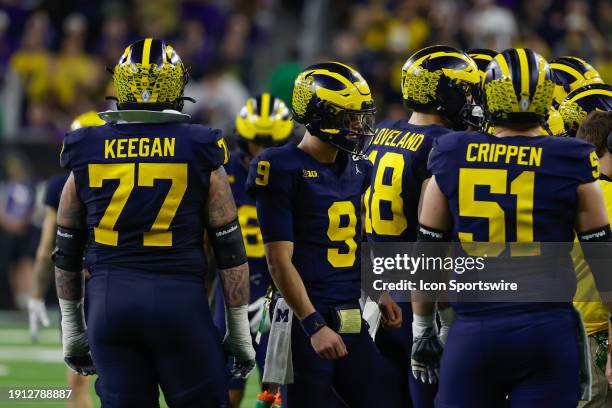 Michigan Wolverines quarterback J.J. McCarthy is in the huddle of players during a timeout of the CFP National Championship game Michigan Wolverines...