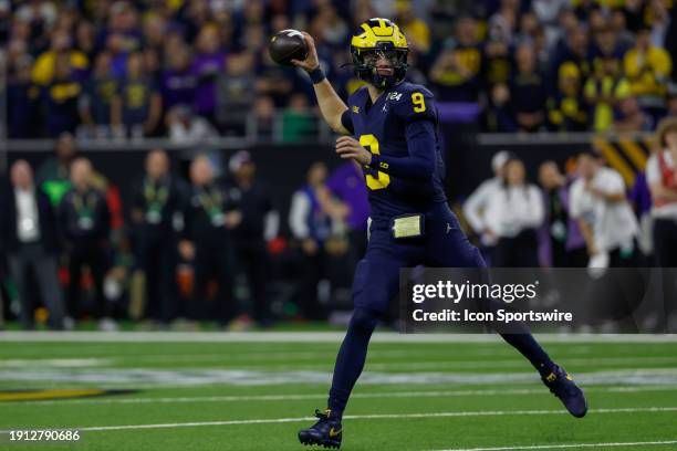 Michigan Wolverines quarterback J.J. McCarthy rolls out for a pass during the CFP National Championship game Michigan Wolverines and Washington...