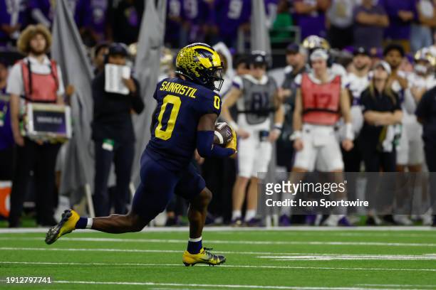 Michigan Wolverines defensive back Mike Sainristil runs back an interception during the CFP National Championship game Michigan Wolverines and...
