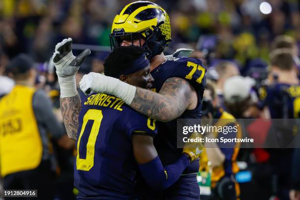 Michigan Wolverines defensive back Mike Sainristil gets a hug from Michigan Wolverines offensive lineman Trevor Keegan after their team wins the CFP...