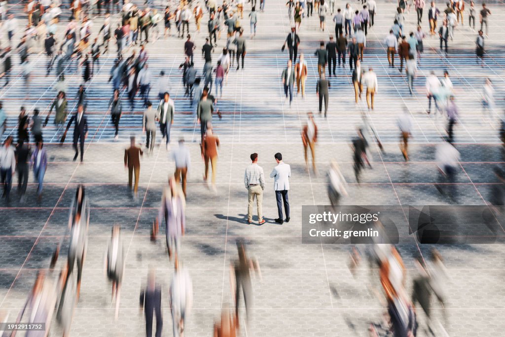 Businessmen on the street standing in crowds of walking people