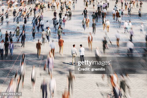 Businessmen on the street standing in crowds of walking people Businessmen on the street standing in crowds of walking people