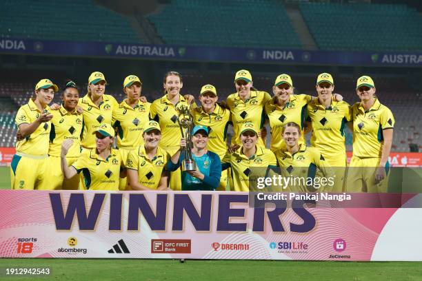 Players of Australia celebrate with the series trophy after winning the Women's T20I match between India and Australia at DY Patil Stadium on January...