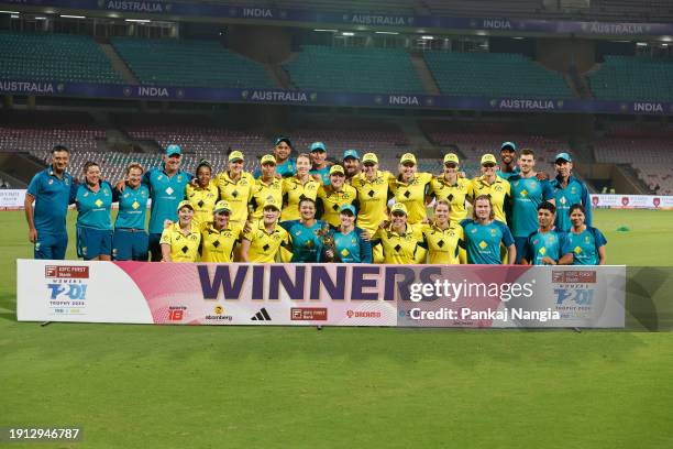 Players of Australia celebrate with the series trophy after winning the Women's T20I match between India and Australia at DY Patil Stadium on January...