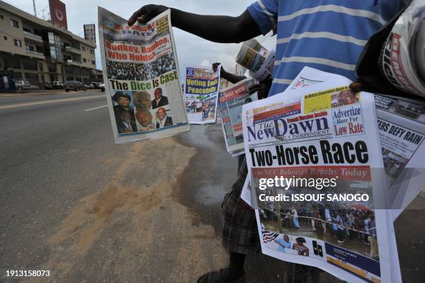 People sell newspapers on a street in Monrovia on October 12 a day after Liberia's second post-war polls in which incumbent president Ellen Johnson...