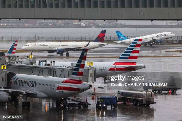 An Airbus A320 passengers aircraft of JetBlue airlines taking-off to Tampa is pictured while an Airbus A319 of Delta airlines is taxiing and two...