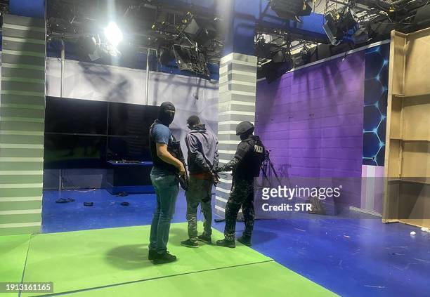 Police officers arrest one of the unidentified gunmen who burst into a studio of the state-owned TC television while live, in Guayaquil, Ecuador, on...